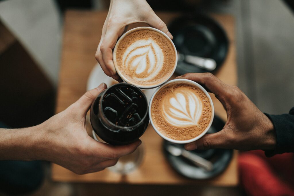 Three people drinking coffee together, demonstrating the community energy offered living at Opus.